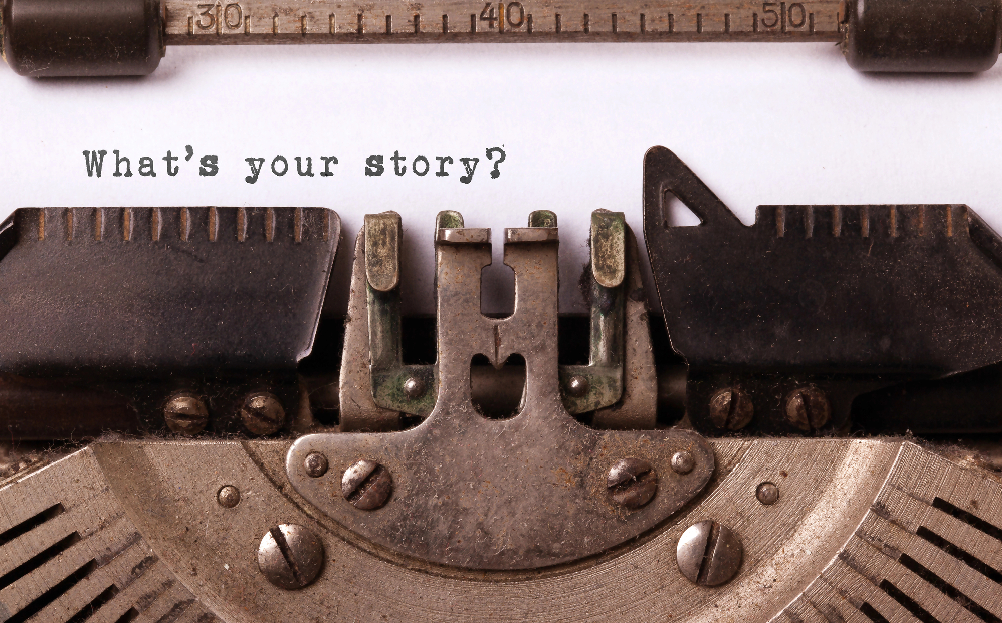 Text on a page in an old-fashioned typewriter saying "What's your story?"