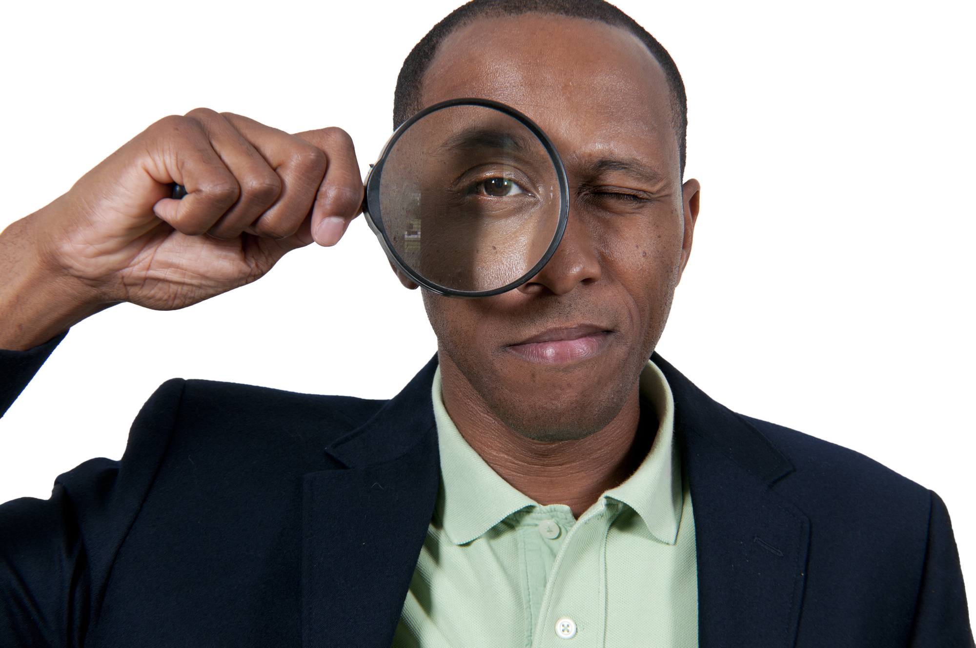 Photograph of a black man looking at the camera through a magnifying glass